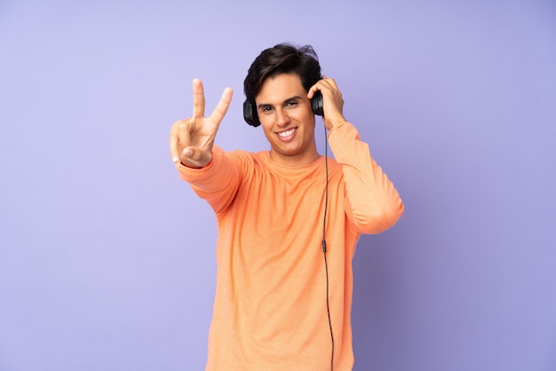 Man over purple wall listening music and singing