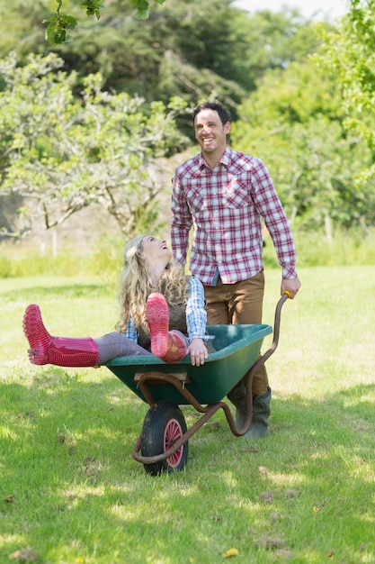 Man pushing his girlfriend in a wheelbarrow