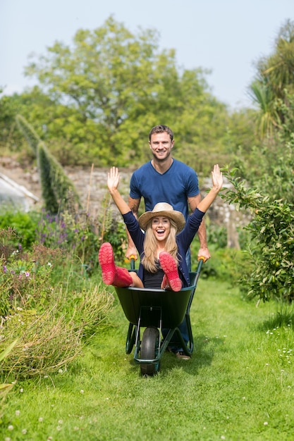 Man pushing his girlfriend in a wheelbarrow