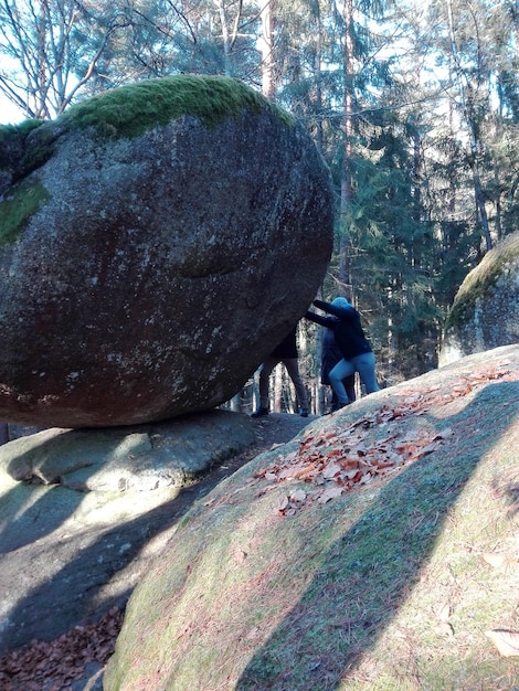 Foto uomo che spinge la roccia