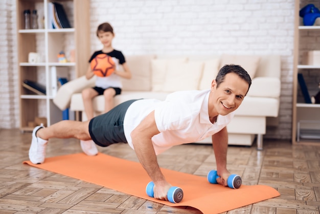 The man pushup, holding a dumbbell.