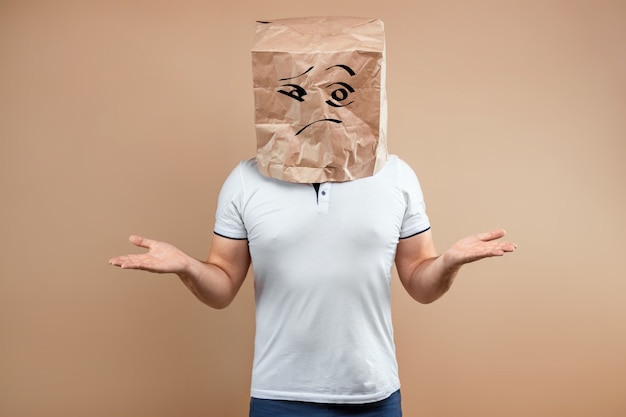 The man put a paper bag on his head, spreads his arms to the sides, despondency, depression. 