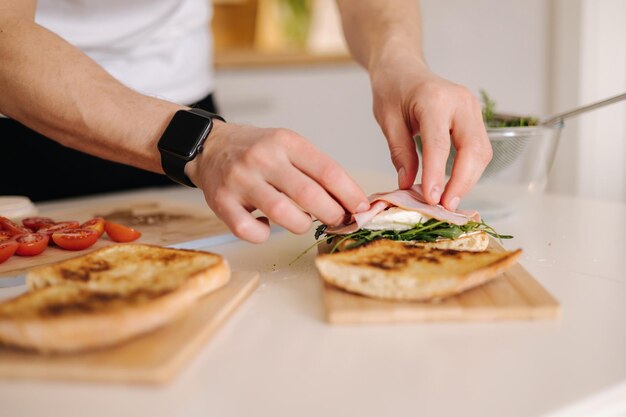 Man put slice of italian prosciutto on top of bruschetta healthy home made food