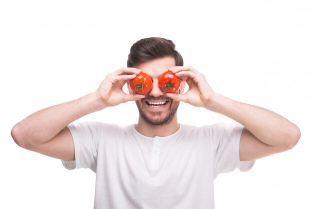 Фото Человек положил помидоры на глаза и улыбается.