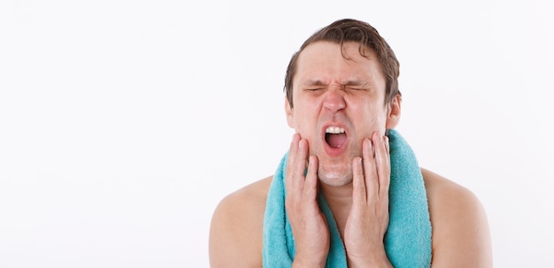 A man puts aftershave on his face.