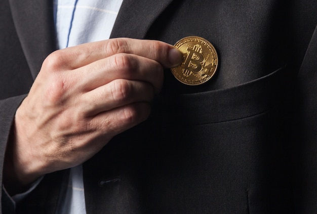 Man puts bitcoin in pocket of jacket.