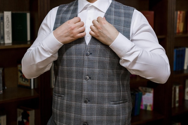 Photo man puts on a suit in the room