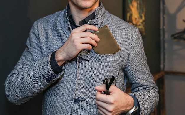 A man puts a wallet in the breast pocket of his jacket