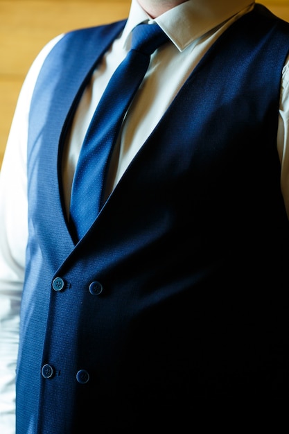 Man puts on a wedding suit and accessories on the wedding day.