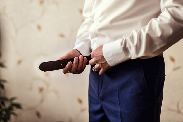 Man putting on a belt, Businessman, Politician, man's style, male hands closeup, American businessman, European businessman, a businessman from Asia, People, business, fashion and clothing concept