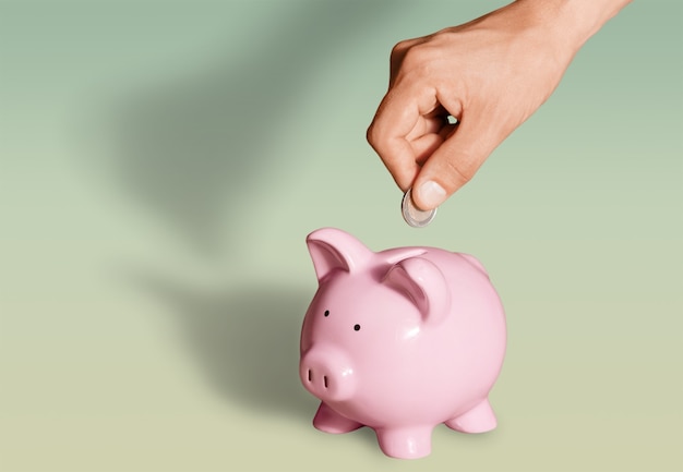 Man putting coin in pig moneybox