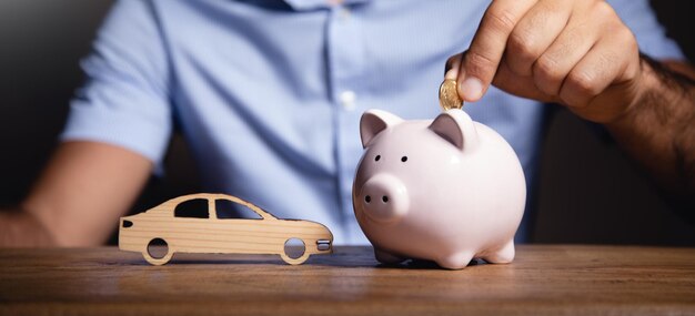 Man Putting Coin In Piggy Bank For Car