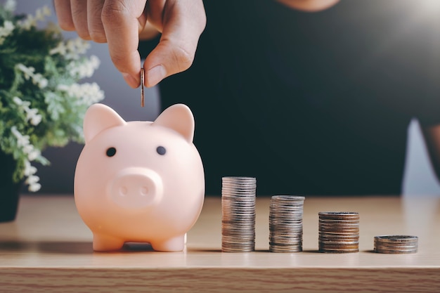 Man putting coins in a piggy bank