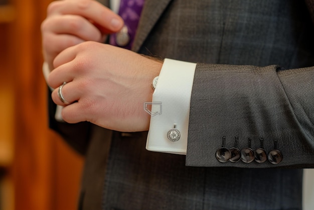 man putting on his cufflinks