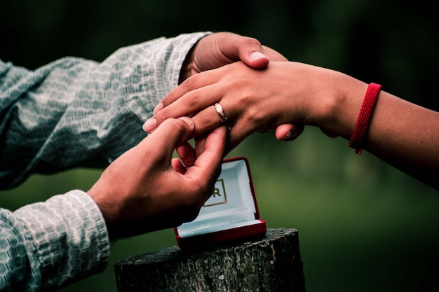 Мужчина надевает кольцо на палец женщины