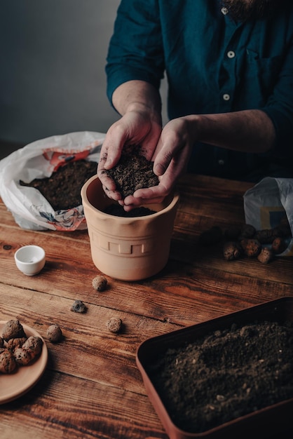 Man Putting Soil into Terracotta Pot