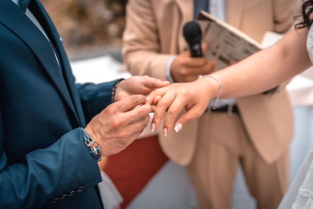 Uomo che mette l'anello nuziale alla sposa alla cerimonia di nozze, momenti essenziali nella relazione di coppia, foto alla celebrazione del matrimonio