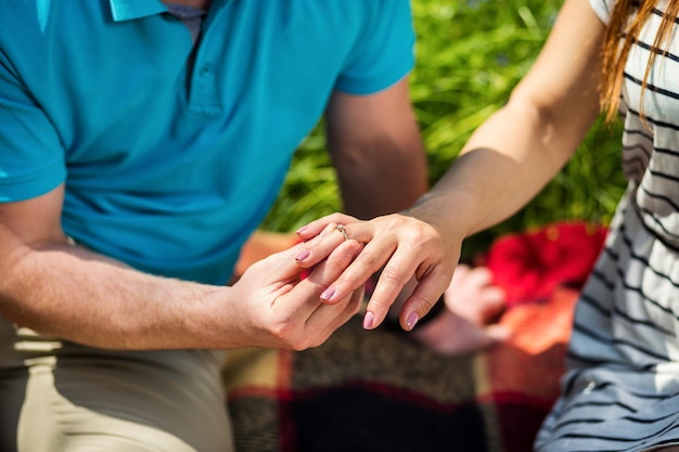 写真 男性が女性の手に結婚指輪を置く