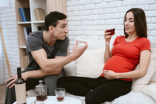 A man quarrels with a pregnant girl who drinks alcohol.