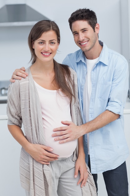 Man raakt de buik van zijn zwangere vrouw aan