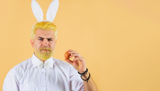 Man in rabbit ears with easter egg spring holidays hunting eggs bunny guy preparing for easter