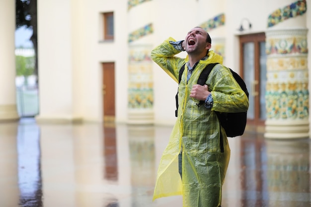 Photo a man in a raincoat on a rainy day in the city