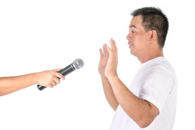 Man raises his hands to avoid speaking on microphone