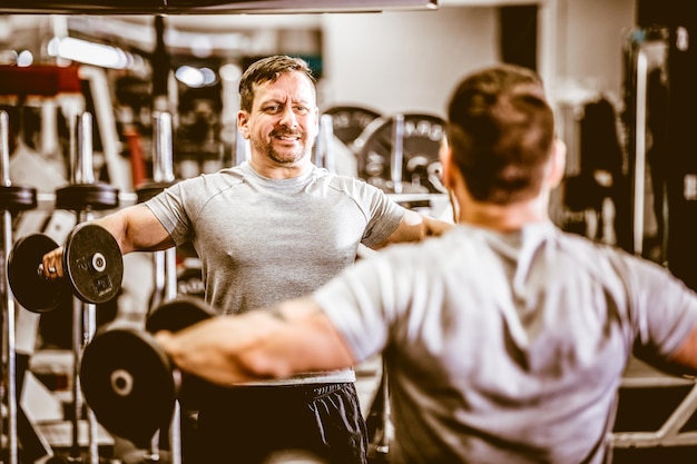 Photo man raising heavy dumbbells