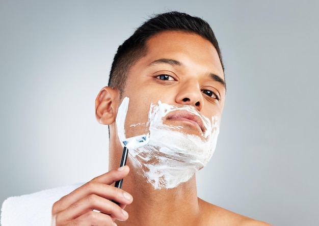 Photo man razor and skincare in beauty for grooming shave or clean hygiene against a grey studio background male face shaving beard with cream cosmetics and care for healthy or fresh skin
