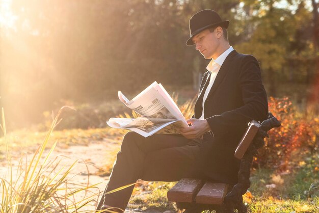 写真 日没時に公園で新聞を読んでいる人