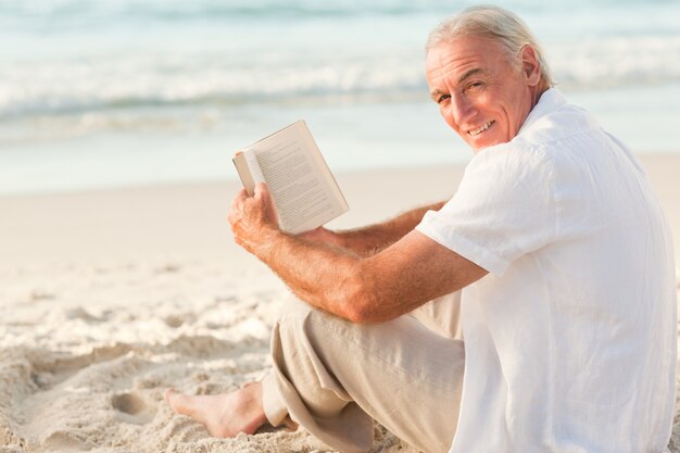 Man reading a book on the beach