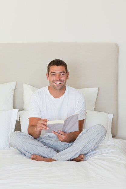 Man reading a book on the bed