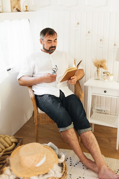 Man reading book in bedroom