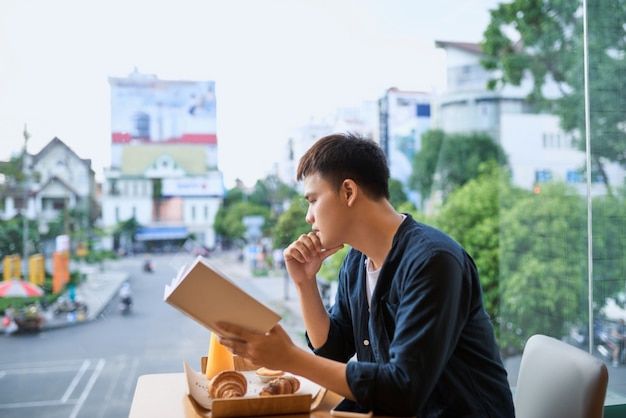 コーヒーショップで本を読んでいる男