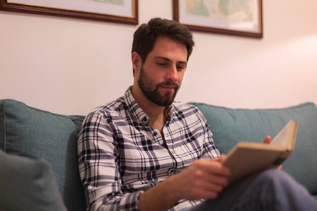 A man reading a book on a couch