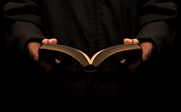 Photo a man reading a book in the dark