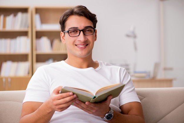 Man reading book sitting in couch sofa