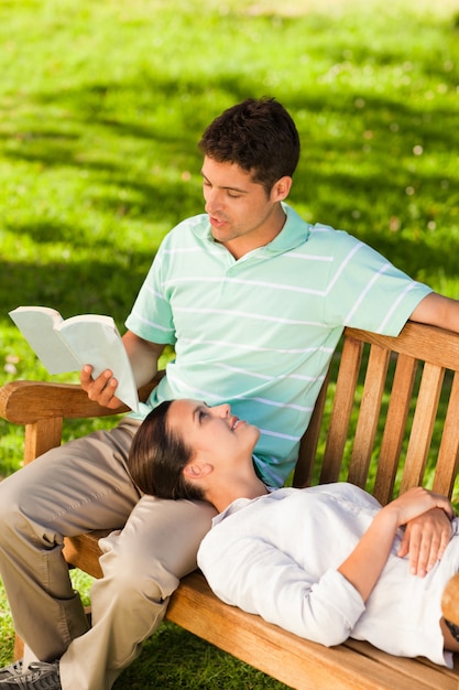 Uomo che legge un libro con la sua ragazza