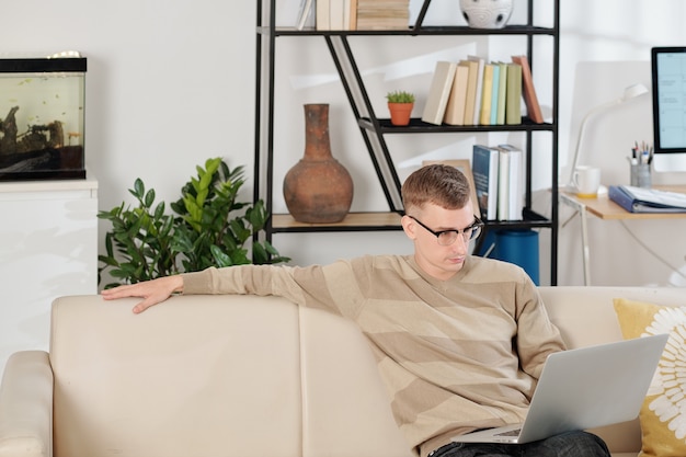 Man reading document on laptop