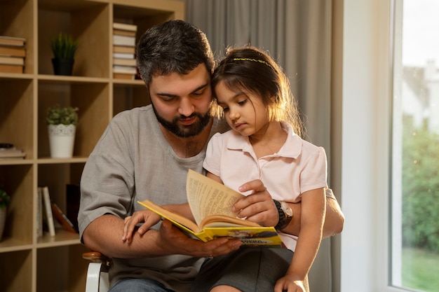 Photo man reading to girl front view