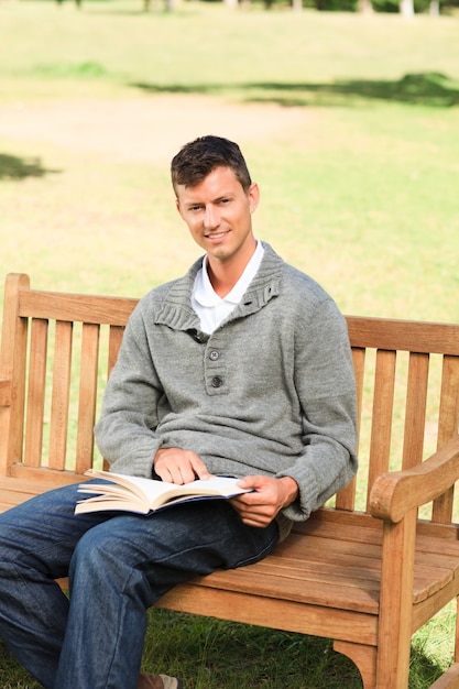 Man reading his book on the bench