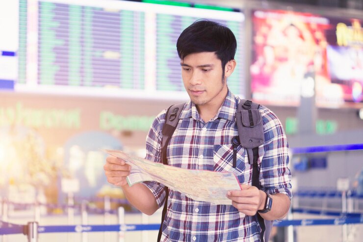 Photo man reading map while standing at airport terminal