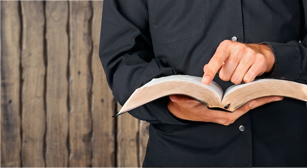 Man reading old heavy book on background