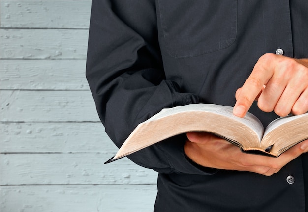 Man reading old heavy book on background