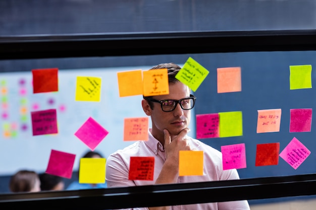 man reading a post it on a window