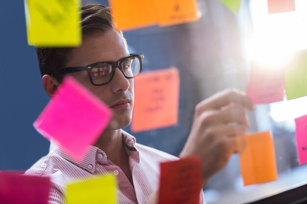 man reading sticky notes on a window