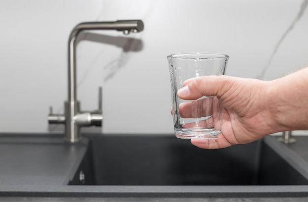 Man ready to pouring filtered water into glass clean water and healthy life