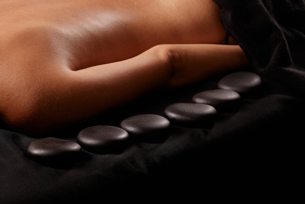 A man receives a hot stone massage a masseur gives a stone massage