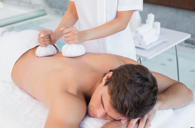 Man receiving back massage at spa center