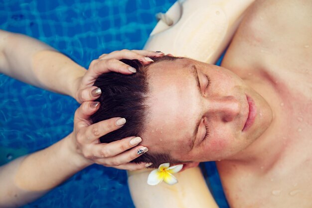 Man receiving head massage in water